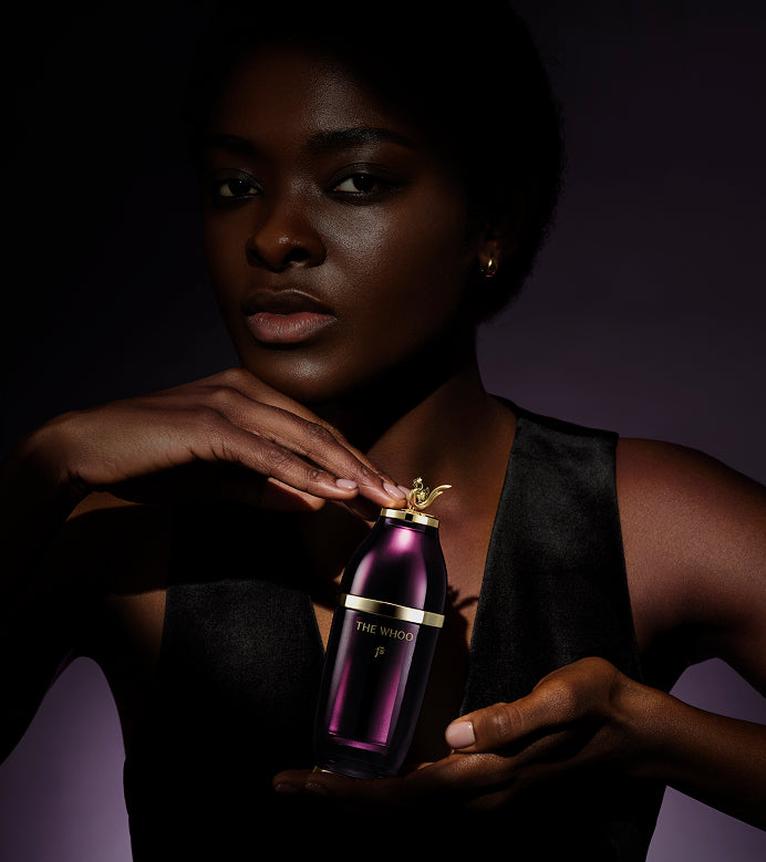 A woman holding the Imperial Youth Concentrate Serum, showcasing its luxury design.