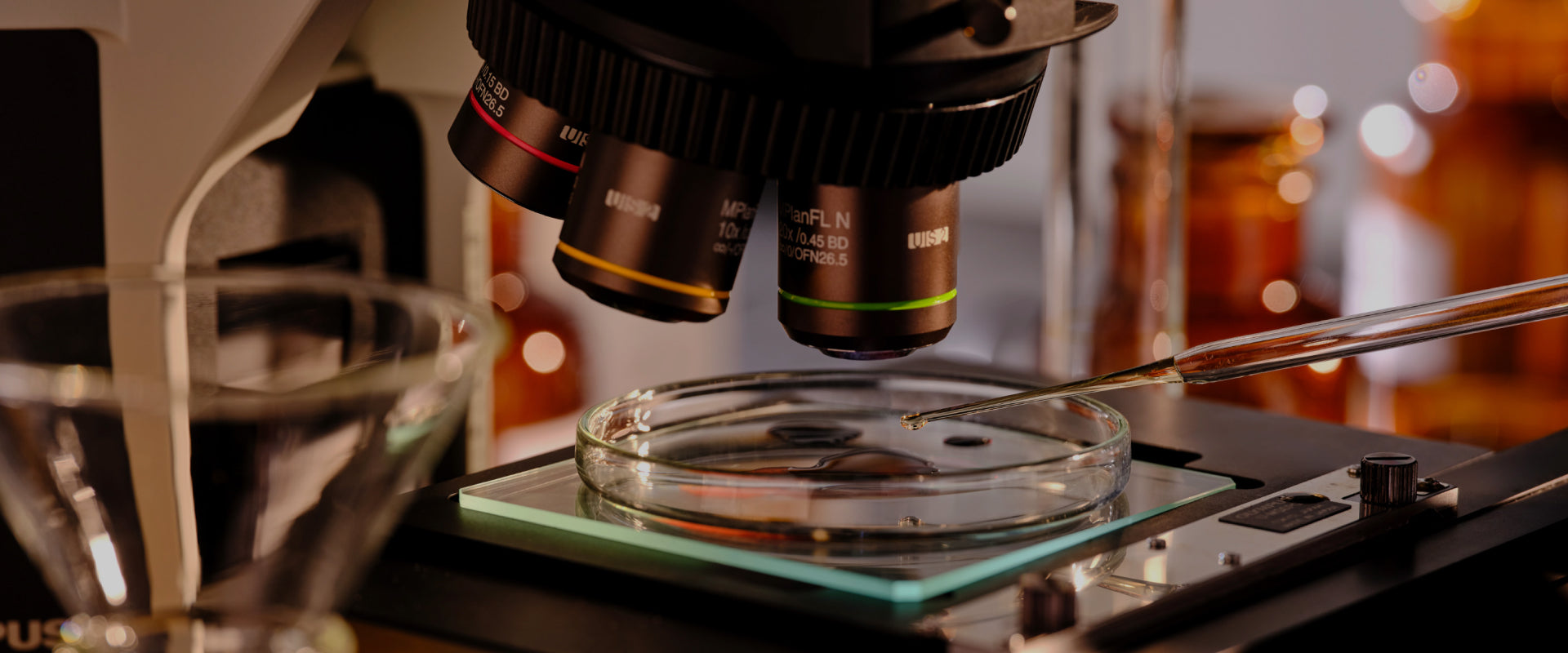 A close-up of a microscope and petri dish on a laboratory table, representing scientific research in skincare.