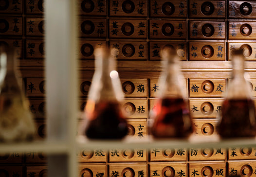 Traditional wooden drawers with Korean herbal medicine labels in black calligraphy, symbolizing Korean medicinal recourses.