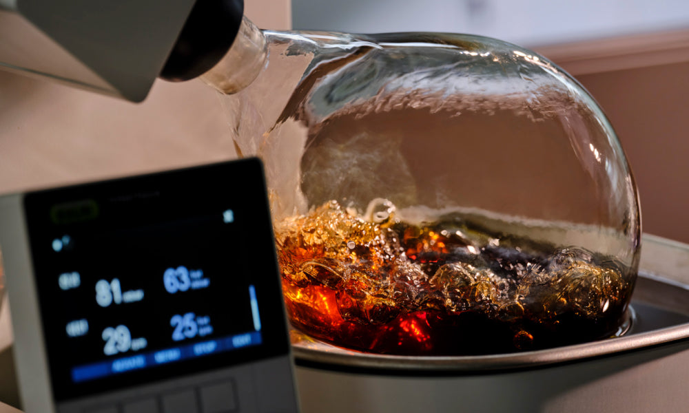 A laboratory device processing herbal ingredients with boiling extracts inside a glass container, illustrating the development of Gong Jin Solution™.